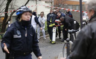 Firefighters carry a victim on a stretcher at the scene after a shooting at the Paris offices of Charlie Hebdo, a satirical news