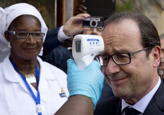 French President Hollande has his temperature measured upon his arrival at the Donka Hospital in Conakry