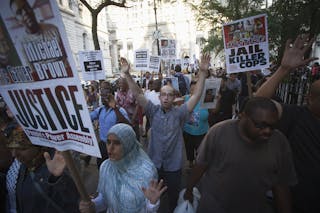 Protesters hold signs and chant "Hands up. Don't Shoot" during a protest against the police in Ferguson, Missouri, in the Manhat