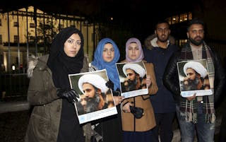 Protesters hold placards as they demonstrate against the execution of prominent Shi'ite cleric Sheikh Nimr al-Nimr outside the S