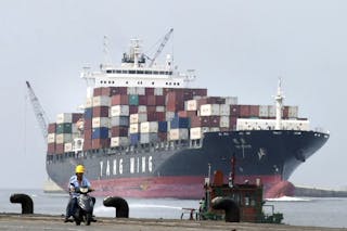 貨櫃_People ride a motorcycle while a container ship passes by at Keelung port in northern Taiwan