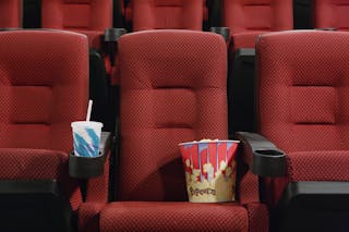 Popcorn and Soft Drink in Empty Seat at the Movie Theater