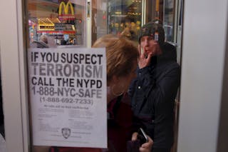 A sign asking for the public's help in stopping terrorism is posted on the window of a McDonalds outlet in the Times Square area