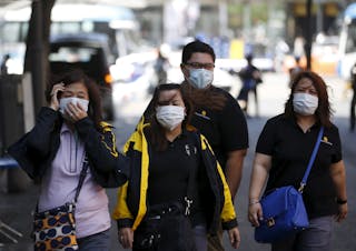 Tourists wearing masks to prevent contracting Middle East Respiratory Syndrome (MERS), walk at Myeongdong shopping district in c