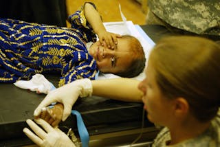 Afghan child reacts to drip needle inserted in arm