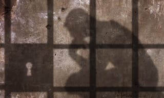 監獄＿坐牢＿Thinking man Shadow Under Jail Bars.