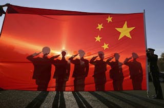 Retired paramilitary policemen, who conduct the daily national flag raising and lowering ceremony on Tiananmen Square, salute to