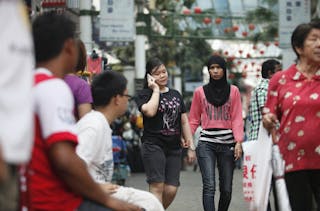 Two women hold hands as they walk along China Town in Kuala Lumpur