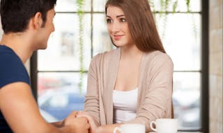 True feelings. Beautiful young couple sitting together at the restaurant and holding hands