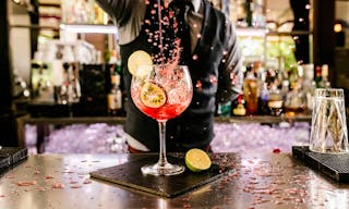 Expert barman is making cocktail at night club.