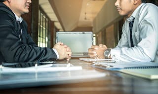 Negotiation of two statesman with clasped hands in office. Two men's hand on a desk. Negotiating business concept.