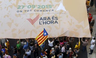 Catalan pro-independence supporters display a giant banner at Sant Jaume square in Barcelona