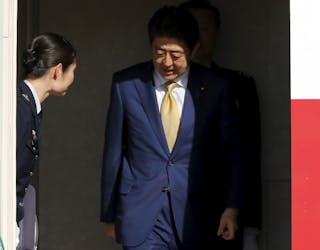 Japan's Prime Minister Shinzo Abe disembarks from his official plane to attend the upcoming Nuclear Security Summit meetings in 