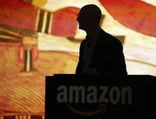 Amazon CEO Bezos is silhouetted during a presentation of his company's new Fire smartphone in Seattle