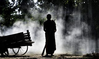 A Buddhist monk sweeps the temple grounds.