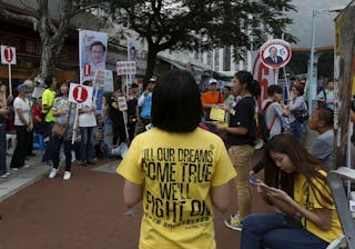 A supporter from pro-democracy group Civic Passion stands in front of supporters of other candidates during a district council e