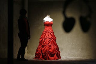 A visitor looks at a wedding dress displayed at the Museum of Broken Relationships installed at the CentQuatre exhibition hall i