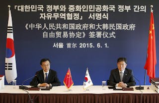 China's Commerce Minister Gao Hucheng (L) speaks besides South Korea's Trade, Industry and Energy Minister Yoon Sang-Jick during