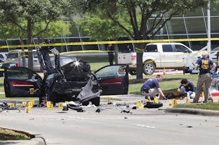 Local police and FBI investigators collect evidence, including a rifle, where two gunmen were shot dead after their bodies were 