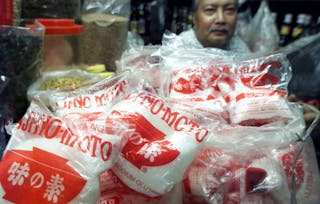 AN INDONESIAN SHOPKEEPER SITS BY RECALLED MSG TASTE ENHANCER IN JAKARTA.