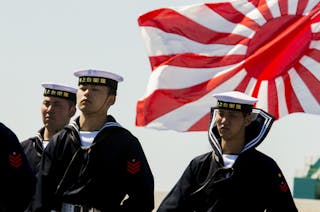 Soldiers of Japan's Maritime Self Defense Force stand in front of the country's naval ensign during the handing-over ceremony of