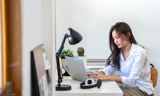 Young beautiful Asian business woman using laptop computer with internet for working from home. Attractive girl creative freelan