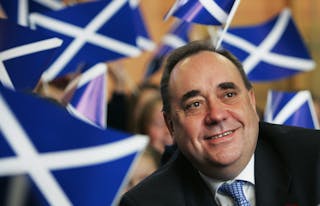 Scotland's First Minister Alex Salmond smiles surrounded by national flags during the launch of the St. Andrew's Day and Winter 