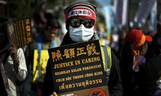 epa05067160 A migrant worker carries placard during a protest near the Presidential office in Taipei, Taiwan, 13 December 2015. Migrant and local workers from Indonesia, Malaysia, Philippines, Vietnam, Thailand, Taiwan and other parts of Asia demand Taiwan government for their better welfare.  EPA/RITCHIE B. TONGO