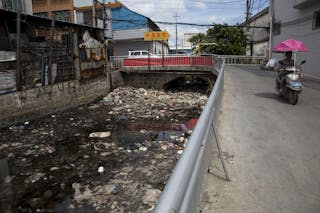 A polluted river flows past a workshop that is used for recycling electronic waste in the township of Guiyu in China's southern Guangdong province June 10, 2015. The town of Guiyu in the economic powerhouse of Guangdong province in China has long been known as one of the worlds largest electronic waste dump sites. At its peak, some 5,000 workshops in the village recycle 15,000 tonnes of waste daily including hard drives, mobile phones, computer screens and computers shipped in from across the world. Many of the workers, however, work in poorly ventilated workshops with little protective gear, prying open discarded electronics with their bare hands. Plastic circuit boards are also melted down to salvage bits of valuable metals such as gold, copper and aluminum. As a result, large amounts of pollutants, heavy metals and chemicals are released into the rivers nearby, severely contaminating local water supplies, devastating farm harvests and damaging the health of residents. The stench of burnt plastic envelops the small town of Guiyu, while some rivers are black with industrial effluent. According to research conducted by Southern Chinas Shantou University, Guiyus air and water is heavily contaminated by toxic metal particles. As a result, children living there have abnormally high levels of lead in their blood, the study found. While most of the e-waste was once imported into China and processed in Guiyu, much more of the discarded e-waste now comes from within China as the country grows in affluence. China now produces 6.1 million metric tonnes of e-waste a year, according to the Ministry of Industry and Information Technology, second only to the U.S with 7.2 million tonnes. REUTERS/Tyrone Siu 

PICTURE 16 OF 18 FOR WIDER IMAGE STORY 