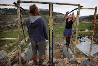 **ADVANCE FOR MONDAY, MAY 11**  In this Friday, April 24, 2009 photo International activists Alice Gray, right, and Roman Gawal work on the construction of a latrine on Abed Rabba's farm on the outskirts of Jerusalem. In a rocky valley on edge of this Palestinian village, British hippie farmers are experimenting with what they consider neglected weapons against Israel's occupation of the West Bank: tree nurseries, rainwater tanks and compost pits, one of them fed directly by the group's toilet. (AP Photo/Tara Todras-Whitehill)