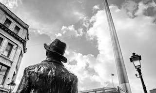 DUBLIN.IRELAND - February 28 , 2018: Bronze James Joyce statue and a Spire in city center.