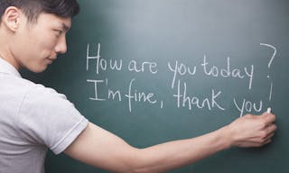 Young man writing English sentences on the blackboard