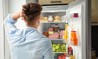 冰箱  Man looking into refrigerator full of products in kitchen