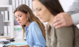 Disgusted employee being victim of sexual harassment and a colleague watching her