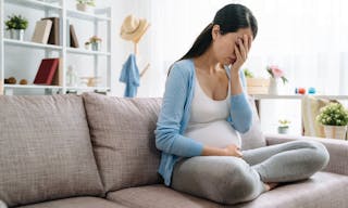 Sad and stressed pregnant woman. asian young female lady at home depressed not ready to be mom sitting on couch sofa at home. be