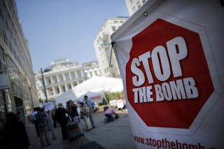 A sign which reads 'Stop the Bomb' is seen as protesters gather outside the hotel where the Iran nuclear talks meetings are bein