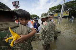 2021年12月20日，在馬來西亞吉隆坡郊區Shah Alam，士兵從受洪水影響的房屋中救出兒童。