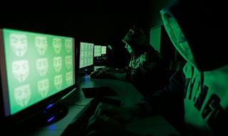 People pose in front of a display showing the word 'cyber' in binary code, in this picture illustration taken in Zenica