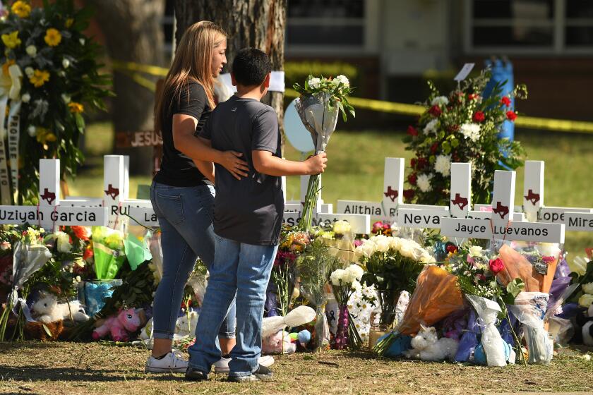 Uvalde, Texas May 26, 2022- Family members place flowers at a memorial outside Rob Elementary School in Uvalde, Texas. Nineteen students and two teachers died when a gunman opened fire in a classroom Tuesday. (Wally Skalij/Los Angeles Times)