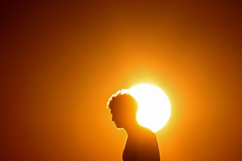 SIGNAL HILL, CALIF. - JULY 5, 2023. July 3 and July 4, 2023, were on record as the hottest days on Earth for global average. Above, a visitor to Signal Hill seeks respite from hotter temperatures inland. (Luis Sinco / Los Angeles Times)