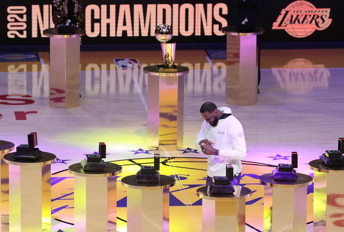 Lakers forward LeBron James puts on his NBA championship ring during a ceremony Dec. 22 at Staples Center. 