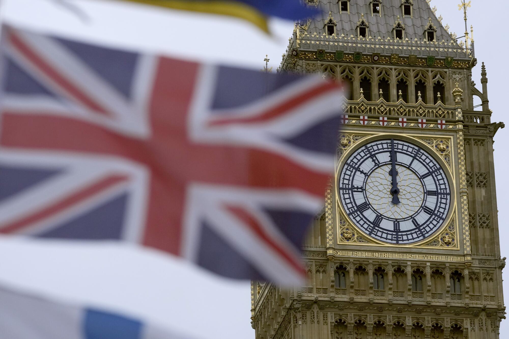 A British flag flies in the foreground in front of Big Ben.