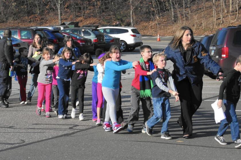 Children are led by police from Sandy Hook Elementary School in Newtown, Conn., after the shooting on Dec. 14, 2012, in which 20 first-graders and six educators were killed.