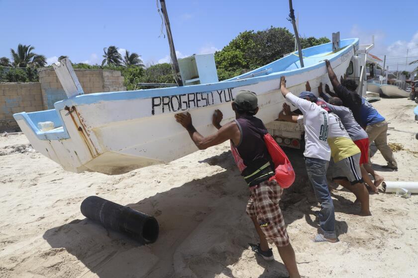 People relocate a boat for its protection ahead of the arrival of Hurricane Beryl in Progreso, Mexico, Thursday, July 4, 2024. (AP Photo/Martin Zetina)