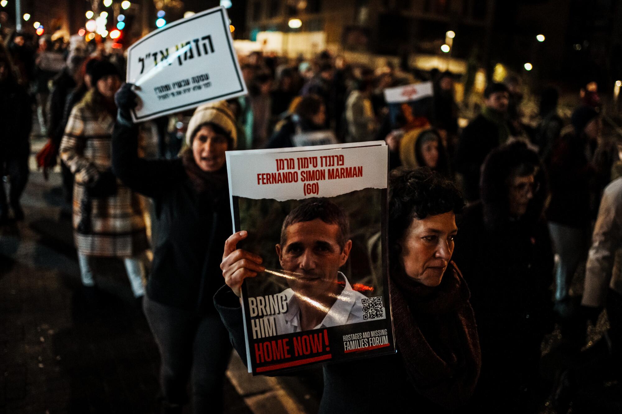 Protesters hold up signs for hostages in Gaza during a march.