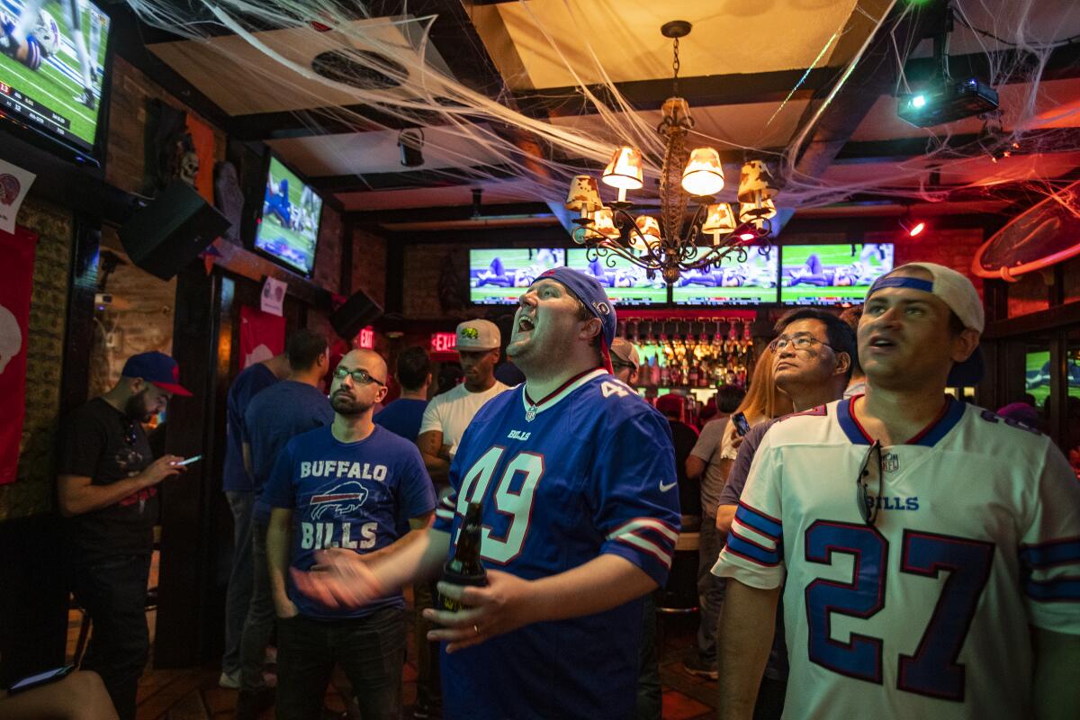 Fans cheer at a bar in Santa Monica while watching NFL games.