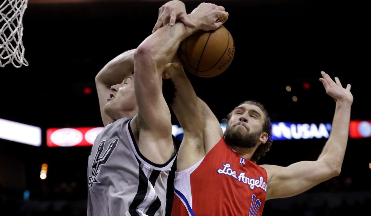 Spurs center Aron Baynes is fouled by the Clippers' Spencer Hawes in the second half Saturday night.