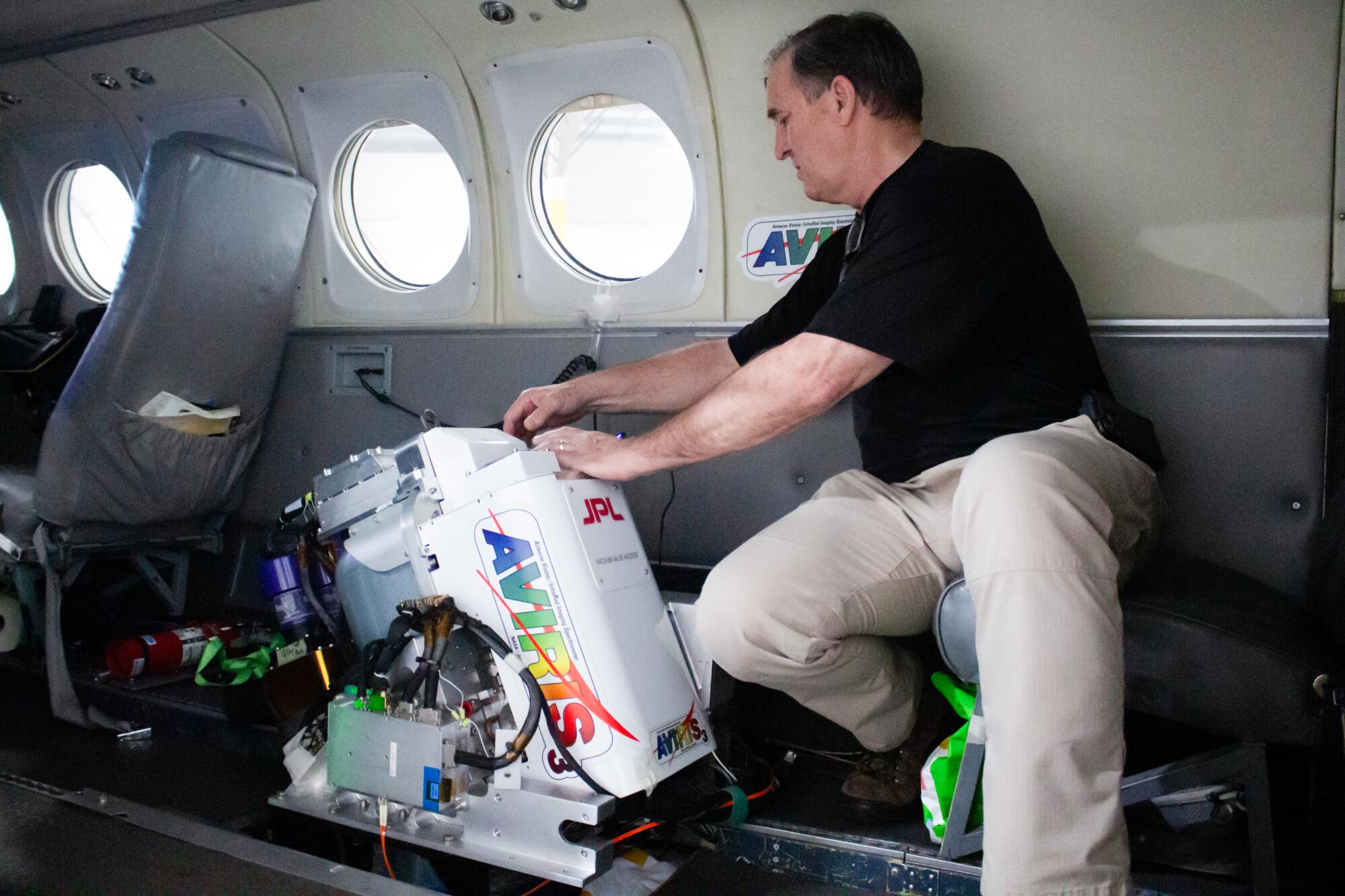 Michael Eastwood handles monitoring equipment inside an aircraft. 