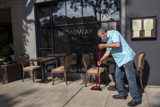 Laguna Beach, CA - MAY 18: Javier Garcia is sweeping outside Broadway by Amar Santana as he is getting ready for dinner hour Tuesday, May 18, 2021 in Laguna Beach, CA. Orange County is now eligible to advance into the yellow tier, the least restrictive in California's reopening framework, according to state data released Tuesday. (Francine Orr / Los Angeles Times)