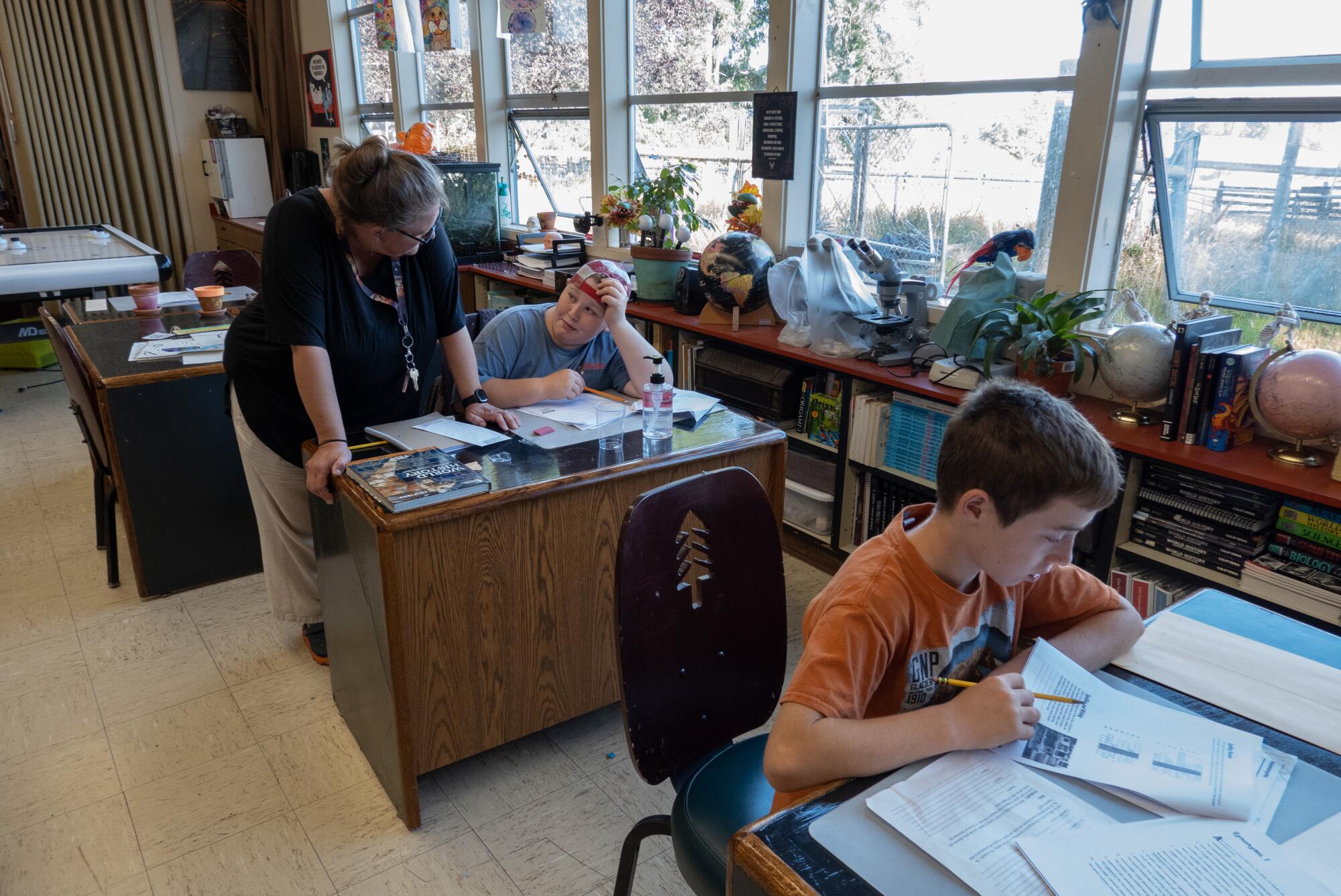 Greta Turney helps sixth-grader Asha Quinlan during class at Kneeland School. 